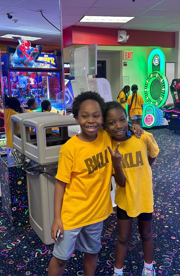 Summer Camp Children hugging on a day trip in an arcade.